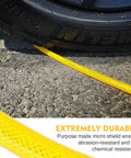Badass 1/4 Inch By 100 Feet Air Compressor Hose Crafted From Tough Reinforced Polyurethane, yellow hose next to a tire on asphalt.