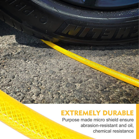 Badass 1/4 Inch By 100 Feet Air Compressor Hose Crafted From Tough Reinforced Polyurethane, yellow hose next to a tire on asphalt.