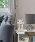 Small Glass Raindrop Bedside Table Lamp with Clear Glass Base and White Fabric Shade on side table in cozy living room