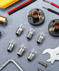 30 Piece E10 Mini Bulbs With Black Plastic Socket Holder for DIY projects and student experiments, warm white light tools included.