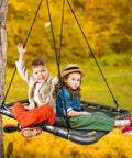 Children enjoying Outdoor Platform Swing For Kids With Rectangular Mat Chair For Tree Or Swing Set Playground Includes Accessories 40 By 30 Inches Black Rectangle Built For Safe Indoor Or Outdoor Fun For Hangouts And Playdates, in a fall setting.