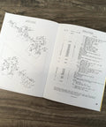 Open Parts Catalog And Service Manual For Model 310 Baler Small Square Hay Baler With Schematic Exploded Views on wooden table.