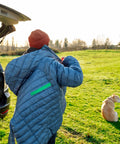 Person wearing a repaired jacket using Tenacious Tape 3 Inch By 20 Inch Clear Vinyl Gear Repair Tape With Two 1.5 Inch Hex Patches outdoors