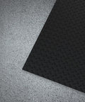 Commercial Grade Vinyl Diamond Plate Floor Mat Knockout Traction Tough As Nails Oil And Chemical Resistant Protection For Heavy Traffic Garages Professional Workshops Black Yellow Border on textured concrete floor.