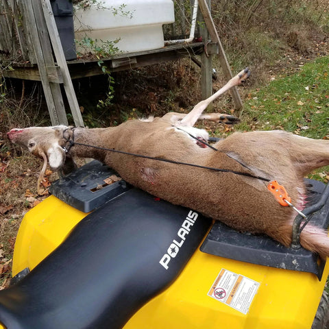 Deer secured with self-locking block and tackle hoist system on ATV, showing ease of transport.