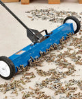 Heavy Duty Magnetic Floor Sweeper With Thirty Six Inch Wide Cleaning Path And Smooth As Butter Rubber Wheels For No Sweat Cleanup On Concrete Asphalt Grass Or Gravel Featuring Dead Simple Dump Lever And Easy Fold Handle In Striking Blue And Black, cleaning nails and screws off the ground.