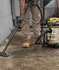 Person using Pro Grade 6 Gallon Wet Dry Vacuum With 4 Peak HP Motor And Stainless Steel Tank In Silver And Yellow outdoors.