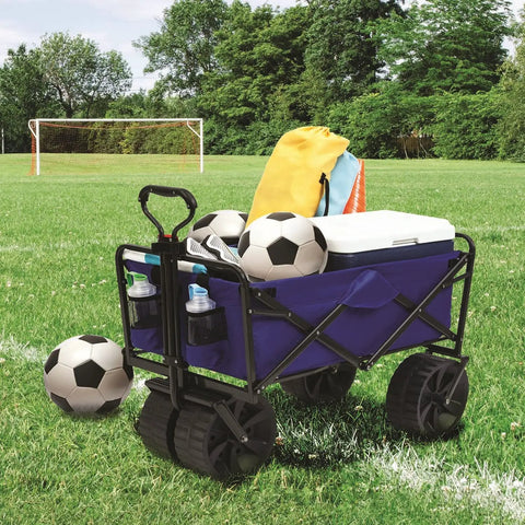 Heavy Duty Collapsible All Terrain Utility Wagon Cart For Beach Adventures With Large Interior No Assembly Required Grab And Go Setup Foldable Beach Wagon Portable Outdoor Gear Cart With Carry Case And Oversized All Terrain Wheels loaded on a grassy field with soccer balls, cooler, and bag, showcasing its storage capacity.