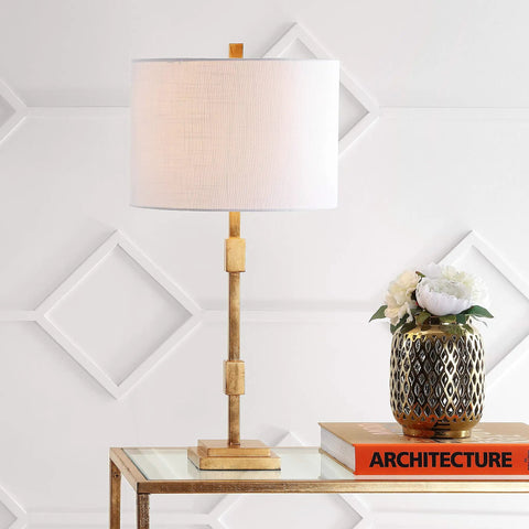 Gold Leaf 29-Inch Geometric Column LED Table Lamp With White Linen Drum Shade on glass table next to decorative vase and book
