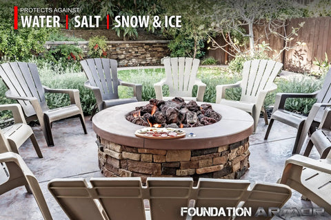 Cozy outdoor seating area featuring a stone fire pit surrounded by water resistant chairs and greenery.