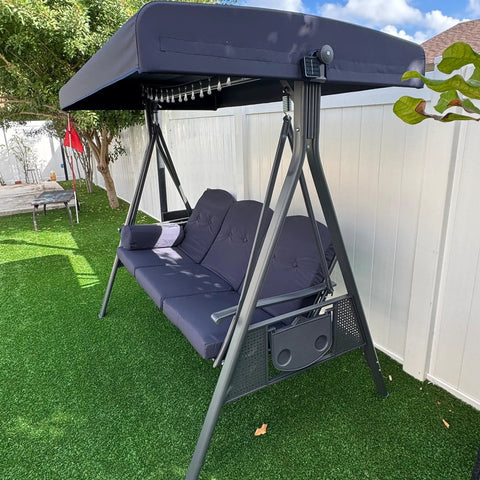 Outdoor Patio Porch Swing With Stand For Three Cushions And Pillow Included Navy Blue All Weather Steel Frame With Adjustable Tilt Canopy For Backyard Front Porch Lawn Three Seat Chill Swing on grass lawn with white fence
