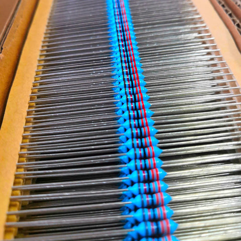 Blue axial resistors in a carrier strip, assorted 1Ω–10MΩ, through-hole kit (front view)