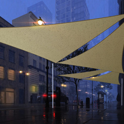 Beige Triangle Sun Shade Sail Canopy 12 Ft By 12 Ft By 12 Ft Waterproof Outdoor Patio Garden UPF50 UV Block 95 Percent Sun Shield 220GSM PES Fabric With 20 Degree Tilt For Quick Water Drain And All Season Shade installed in urban area on rainy night.