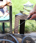 Using 16 Inch Fire Pit Poker With Heat Resistant Resin Handle on outdoor fire pit, showing long reach and two-prong design