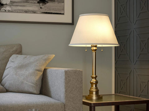 Spyglass Table Lamp With Antique Brass Finish Dope Retro Modern Classic Vibe Linen Shade 30.5 Inch Tall 17 Inch Wide 17 Inch Deep Dual Bulb Ready For Living Room Or Bedroom on side table with sofa.