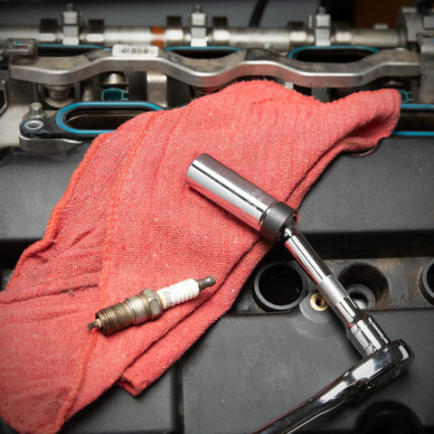 3/8 Inch Drive 6 Point Magnetic Swivel Spark Plug Socket 5/8 Inch By 6 Inch tool on engine with red cloth and spark plug