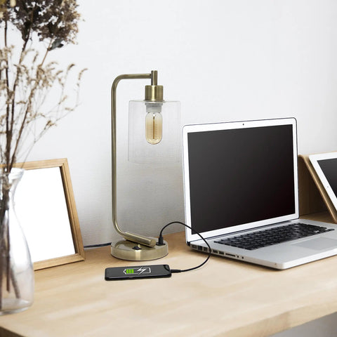 Old School Industrial Lantern Desk Lamp In Rose Gold Finish With Clear Glass Shade next to a laptop on a desk