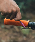 Close-up of orange Lock On Clamp Mountain Bike Handlebar Grips With Lightweight Ergonomic Design being installed on a bike