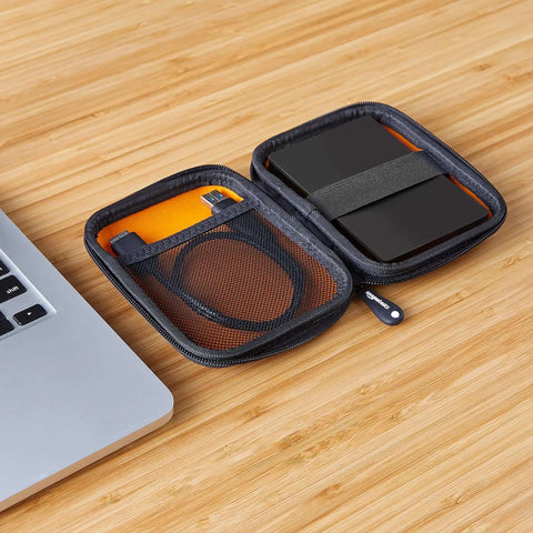 Slick Go To Hella Tough Hardshell Carry Case For Portable External Hard Drives open with cables and black drive inside on wooden desk.
