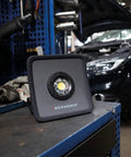 Rechargeable COB LED Floodlight Handheld Beast 2000 Lumen Ultra Slim Work Light with 5-Stage Dimming on workbench