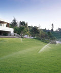 Tough As Nails Gear Drive Pop Up Lawn Sprinkler Boasting Preinstalled Number 6 Nozzle irrigating a lush green lawn.