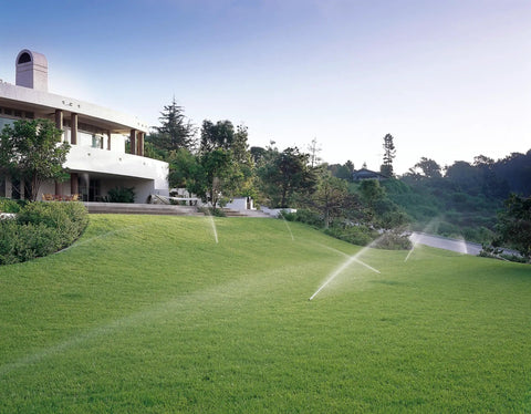 Tough As Nails Gear Drive Pop Up Lawn Sprinkler Boasting Preinstalled Number 6 Nozzle irrigating a lush green lawn.