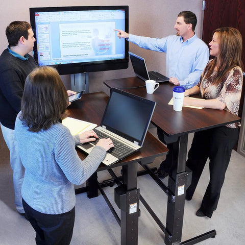 Height Adjustable Standing Desk Supporting Dual Screens And Tablets Heavy Duty Sit Stand Workstation Smooth Manual Crank Adjustment 48 By 24 Inch Rich Walnut Surface in an office setting.
