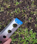 Ultralight Backpacking Trowel 0.48 Oz 13.5 G Blue With Lifetime Warranty Made In USA in use on soil with blue end cap visible.