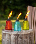 Set Of 3 Molded Glass Tabletop Torches In Rio Red, Key Lime Green, And Ocean Blue For Outdoor Lawn, Patio And Garden Lighting on table