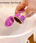 Hand dumping coffee grounds from reusable pod into trash with K Cup Disposable Paper Filters 100 Pack That Fits All Reusable Coffee Pods Compostable And Biodegradable Coffee Filters For Keurig Single Cup Brews Keeps Grounds And Sediment Out For A Smoother Cleaner Brew.