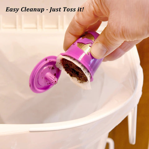 Hand dumping coffee grounds from reusable pod into trash with K Cup Disposable Paper Filters 100 Pack That Fits All Reusable Coffee Pods Compostable And Biodegradable Coffee Filters For Keurig Single Cup Brews Keeps Grounds And Sediment Out For A Smoother Cleaner Brew.
