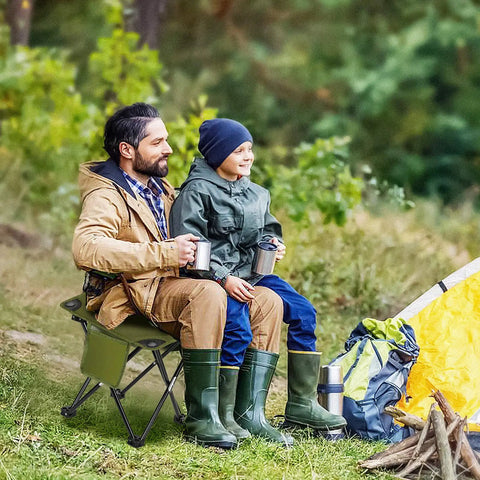 Man and child seated on lightweight camping stool portable folding seat for camping hiking fishing beach picnics and travel with carry bag.