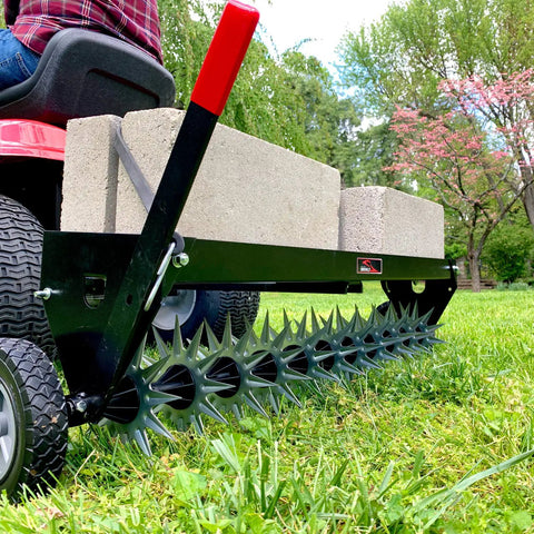 Tow Behind Spike Aerator With Transport Wheels, 40-Inch Lawn Aerator, 11 Tine Stars With 12 Spike Tips in a garden setting