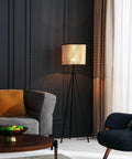 Mid Century Bohemian Tripod Floor Lamp With PVC Rattan Shade And Velvet Rim next to a sofa in a living room