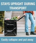 Person pulling 90L Collapsible Rolling Tote with groceries; sturdy black design with wheels, built tough heavy duty utility cart.