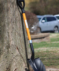 Heavy Duty Digging Shovel 41 Inch With Trenching Blade And Comfortable Handle leaning against a tree outdoors