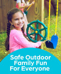 Girl playing with a green Pirate Ship Wheel Outdoor Playset Accessory for Kiddos on a backyard swing set, smiling.
