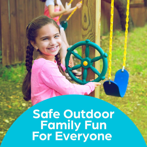 Girl playing with a green Pirate Ship Wheel Outdoor Playset Accessory for Kiddos on a backyard swing set, smiling.