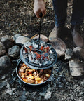 Cooking stew in Six Quart Cast Iron Camping Dutch Oven With Lid Lifter And Storage Bag For Campfire Cooking Stews And Baking Durable Pre Seasoned Outdoor Pot For Camping And Hiking over campfire