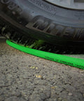 Top Shelf Hybrid Air Compressor Hose 3/8 Inch X 25 Feet Kink Free under a tire on asphalt, showcasing durability.