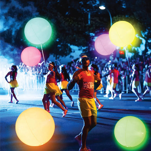 People holding 16 Inch Light Up Glow Beach Ball With 8 LED Modes For Night Pool Fun, Waterproof LED Ball For Adults Teens And Kids.