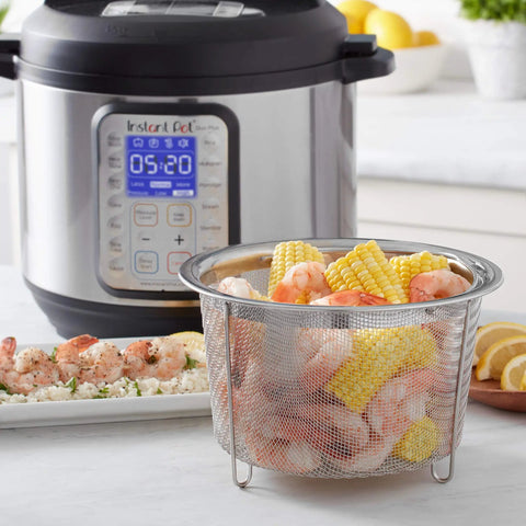 Round Stainless Steel Mesh Steamer Basket For Pressure Cookers filled with corn and shrimp next to an Instant Pot