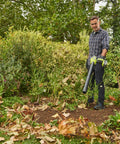 Person using 18V One Plus Brushless Compact Blower Bare Tool With Variable Speed Trigger And Lock On for yard cleanup
