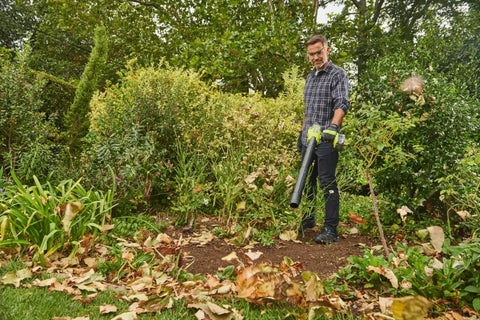 Person using 18V One Plus Brushless Compact Blower Bare Tool With Variable Speed Trigger And Lock On for yard cleanup