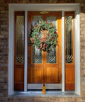 Front door decorated with wreath; Sun Shield Wood Wax With UV Protection For Outdoor Furniture Gallon placed below.