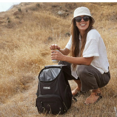 Woman outdoors with 15 Can Capacity Backpack Cooler With Soft Insulated Design Built For On The Go Chill And Road Trip Ready Keeps Ice Up To 24 Hours