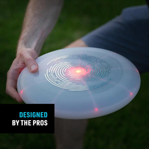 Person holding Flashflight LED Light Up Frisbee Rechargeable Flying Disc with Disc O Tech, illuminated at dusk.