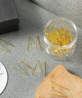 Super Slick Gold Cubicle Hooks For Fabric Partition Walls Tough Stainless Steel Wire Clips in jar on gray surface