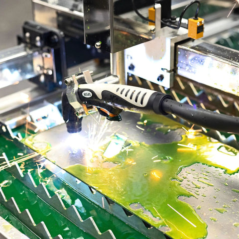 Versa-Cut 2 By 2 CNC Plasma Table in action cutting metal sheet with sparks, featuring LCD touch screen and 10 Gal Waterbed capacity.