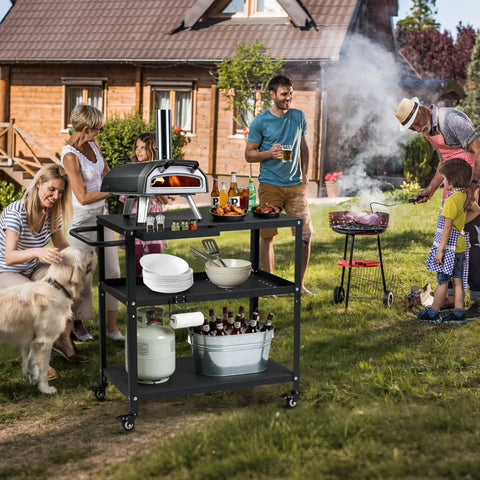Outdoor scene with Grill Cart Table That Rolls On Wheels For Indoor And Outdoor Use with kitchenware, drinks, and pizza oven.